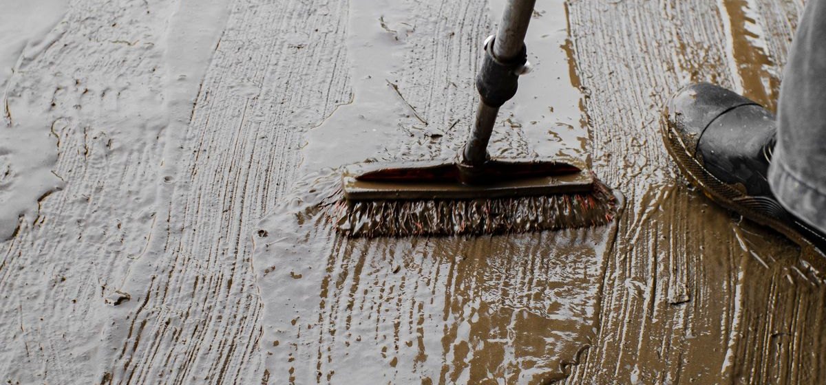 Vloer wordt geschrobd met een schrobber, vuil wordt weggewerkt